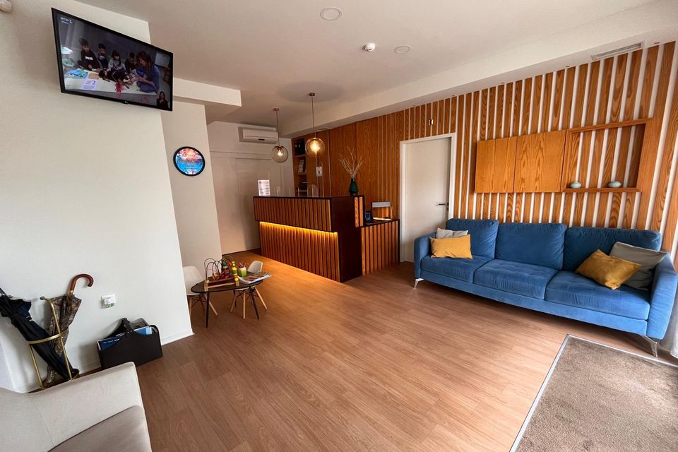 Sala de espera com sofá e painel de madeira